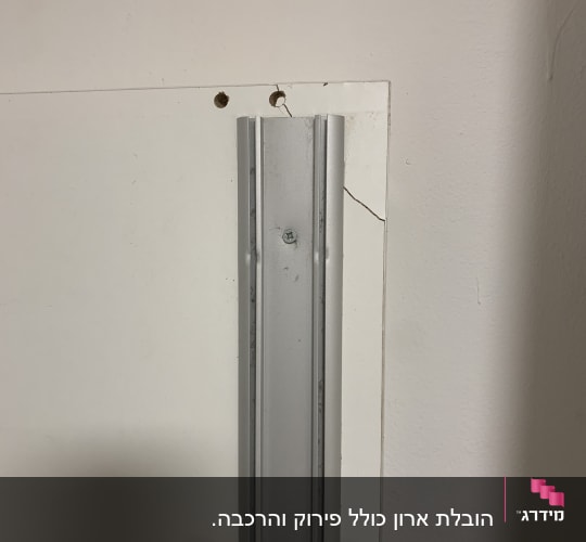 מסילה מתכתית על קיר עם סדקים קטנים